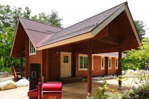 บ้านไม้ Log Cabin พร้อมหลังคาที่จอดรถด้านหน้า