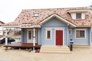 แบบบ้านไม้ Log Cabin สีฟ้าอ่อน ด้านหน้ามีระเบียงให้นั่งห้อยขาน่าสบาย